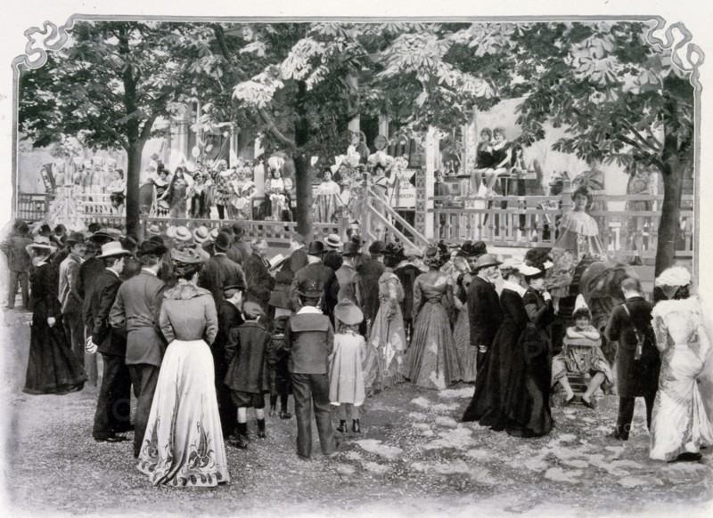 Photograph of a crowd watching a performance in La Rue de Paris entitled the Parade des Auteurs Gais.