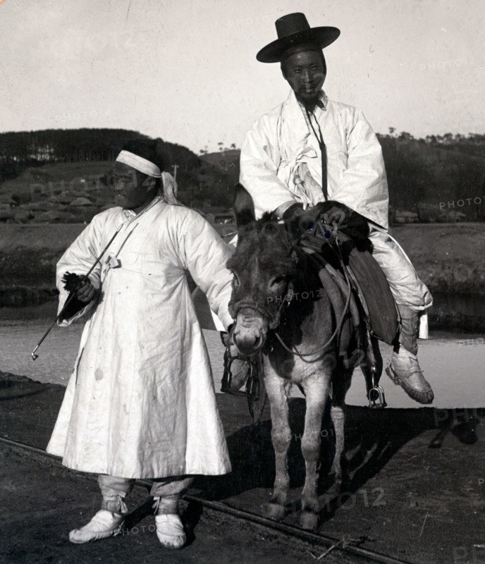 Korean official on a donkey led by a servant. Joseon Era. Circa 1900