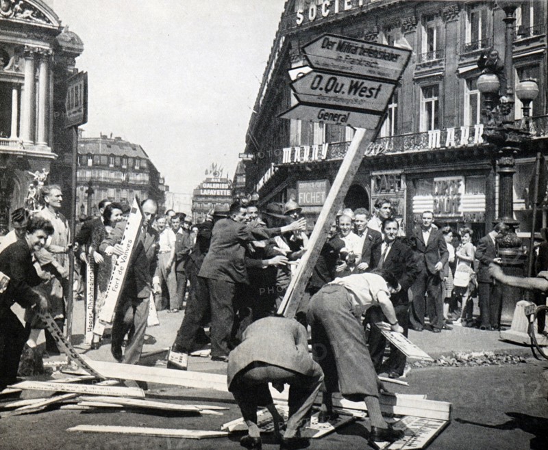 Parisians taking down German signs in Paris after the end of World War II