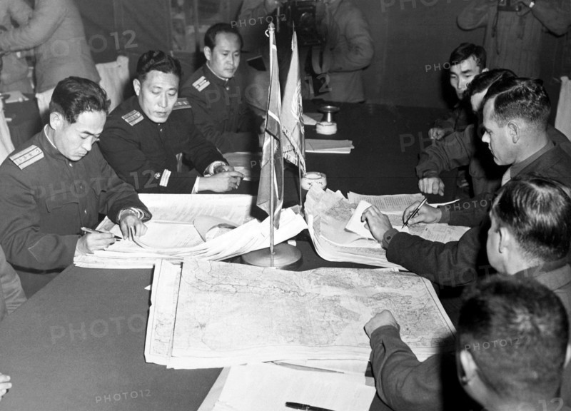 Col. James Murray, Jr., USMC, and Col. Chang Chun San, of the North Korean Communist Army, initial maps showing the north and south boundaries of the demarcation zone, during the Panmunjom cease fire talks