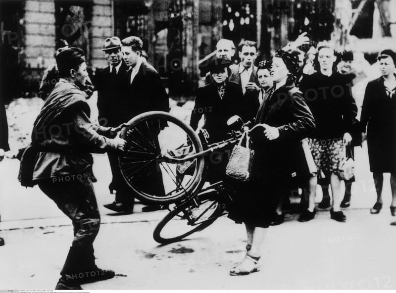 Un soldat soviétique tente d'arracher à une jeune femme sa bicyclette, 1945