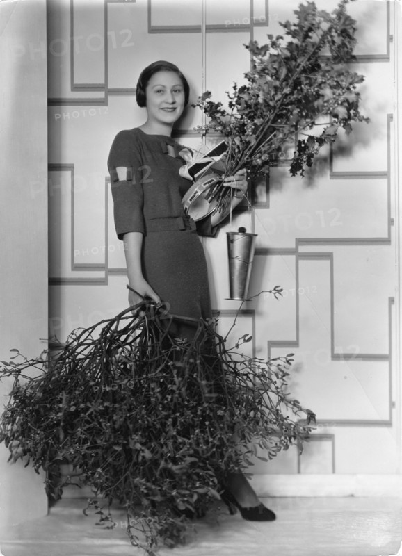 Frau mit Mistelzweigen und Ilex-Zweigen