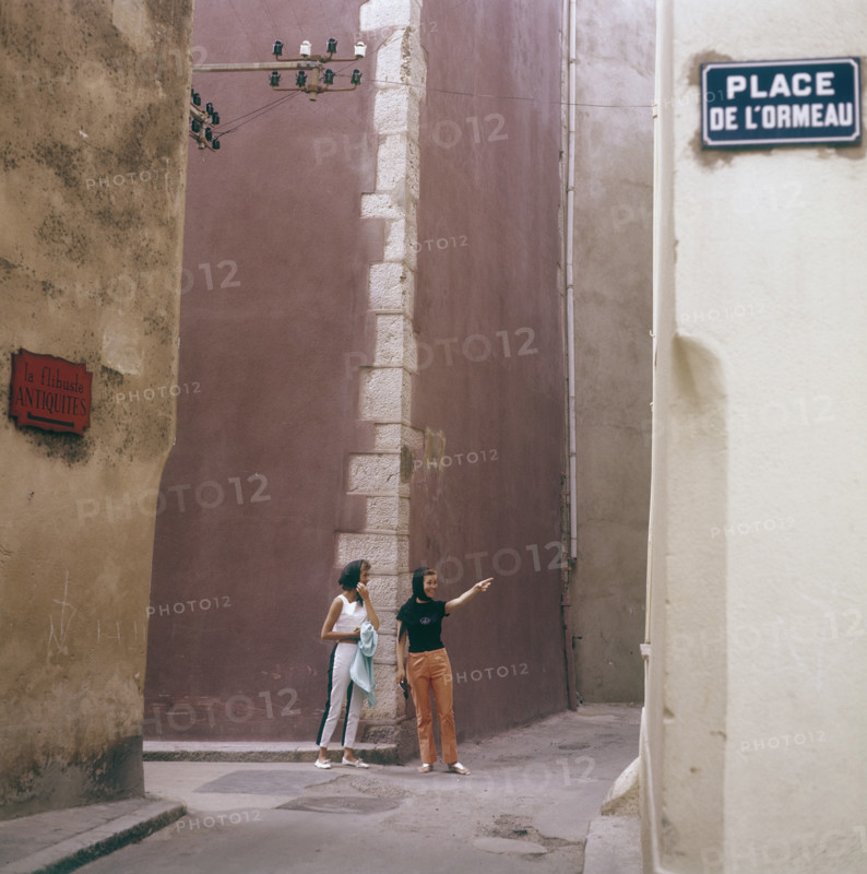In the 1960s. Two female tourists in a street corner in the town Saint-Tropez on the French riviera. T...