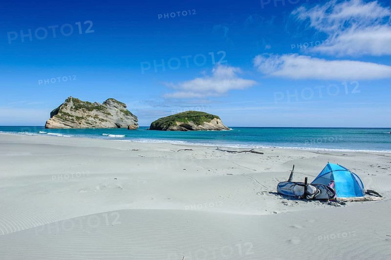 Camping tent on Wharariki Beach with Archway islands in the background