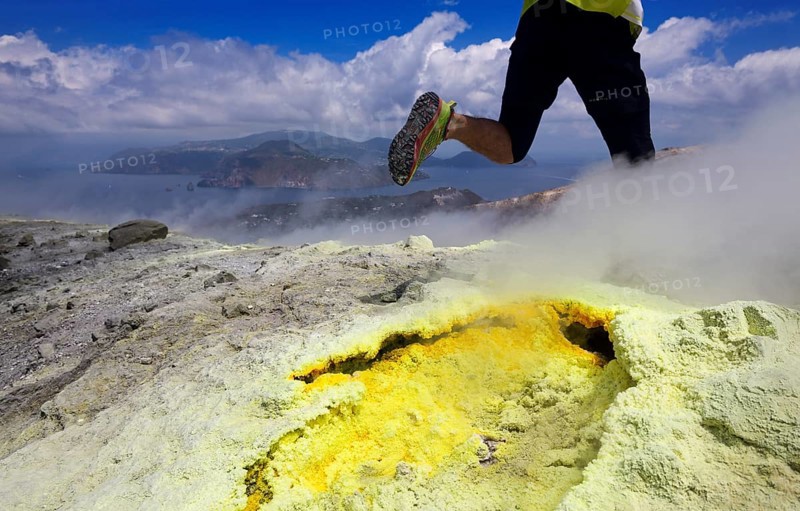 Trailrunner surrounded by sulfur fumaroles and chloride crusts on the crater rim