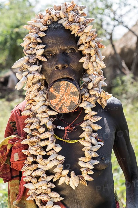 Old woman with lip plates and shells as headdress