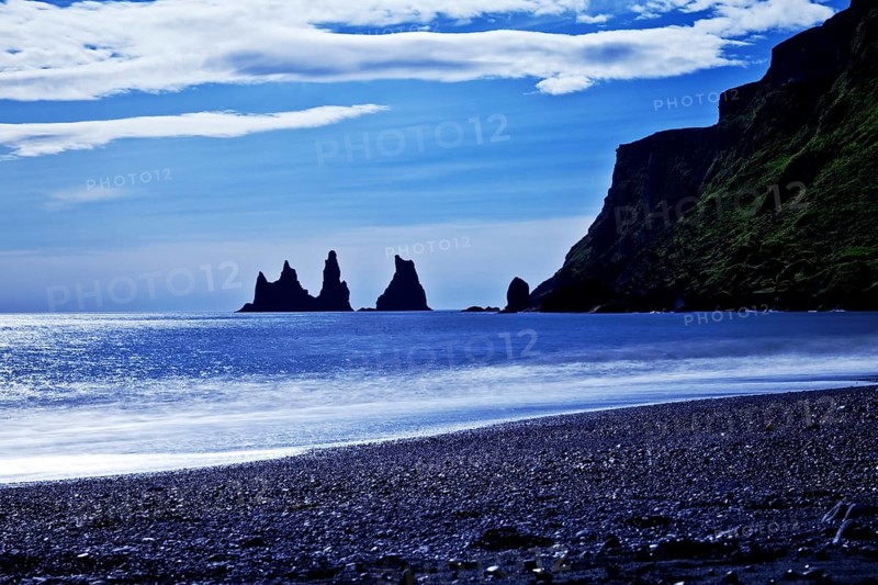 Rock spikes Reynisdrangar with surf on the beach near Vik i Myrdal