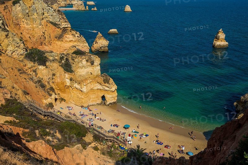 Swimmers on the beach between steep cliffs