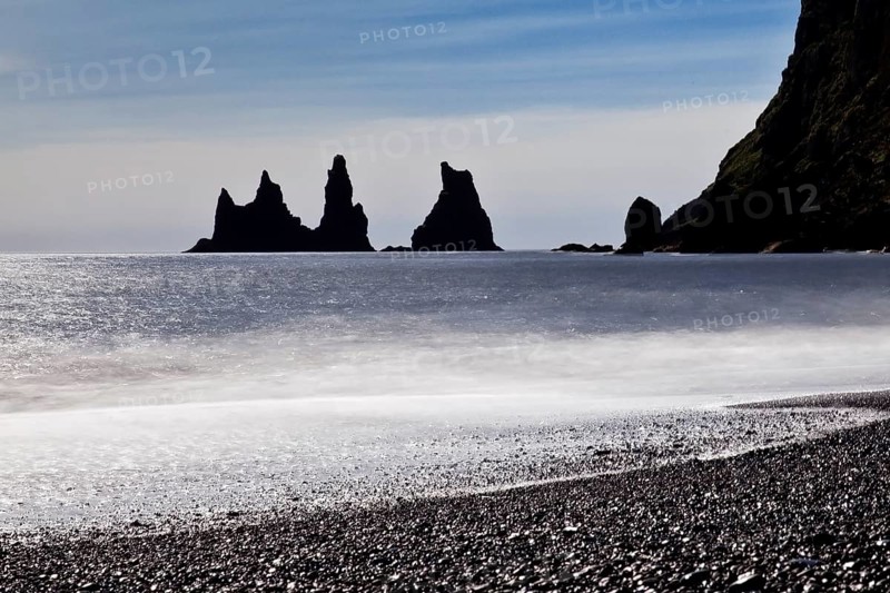 Rock spikes Reynisdrangar with surf on the beach near Vik i Myrdal