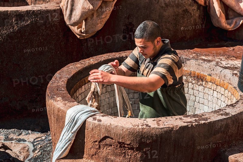 Worker dyeing leather