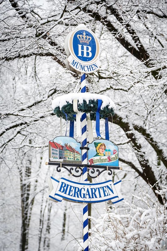 Beer garden sign in front of snow-covered trees