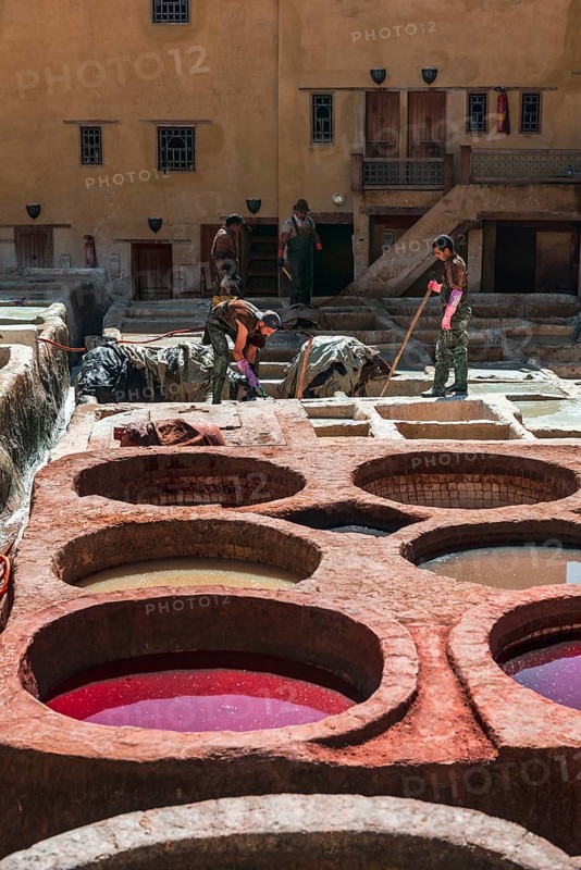 Worker dyeing leather