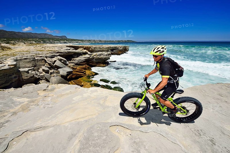 Mountain biker with Fatbike on cliff