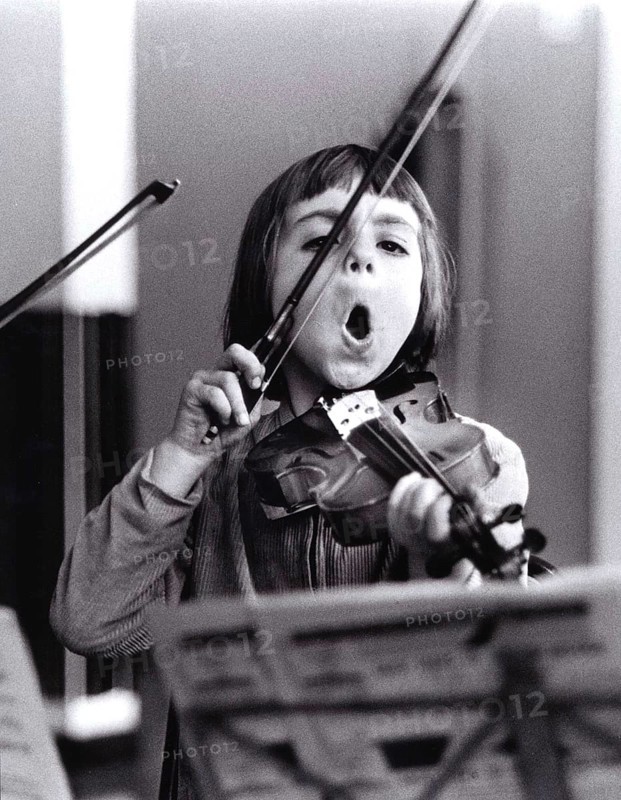 Child plays violin and sings