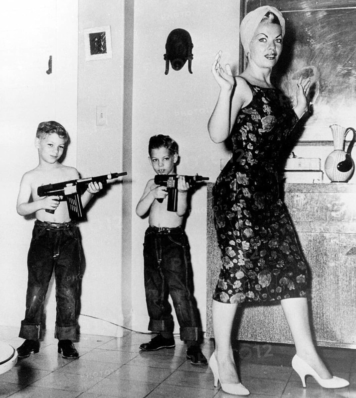 Two boys with rifles against mother