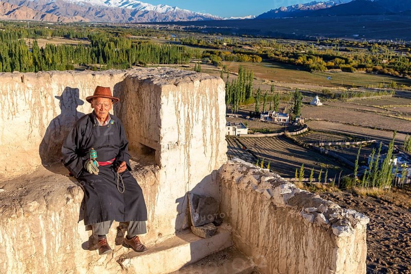 Elderly man taking a rest on a wall