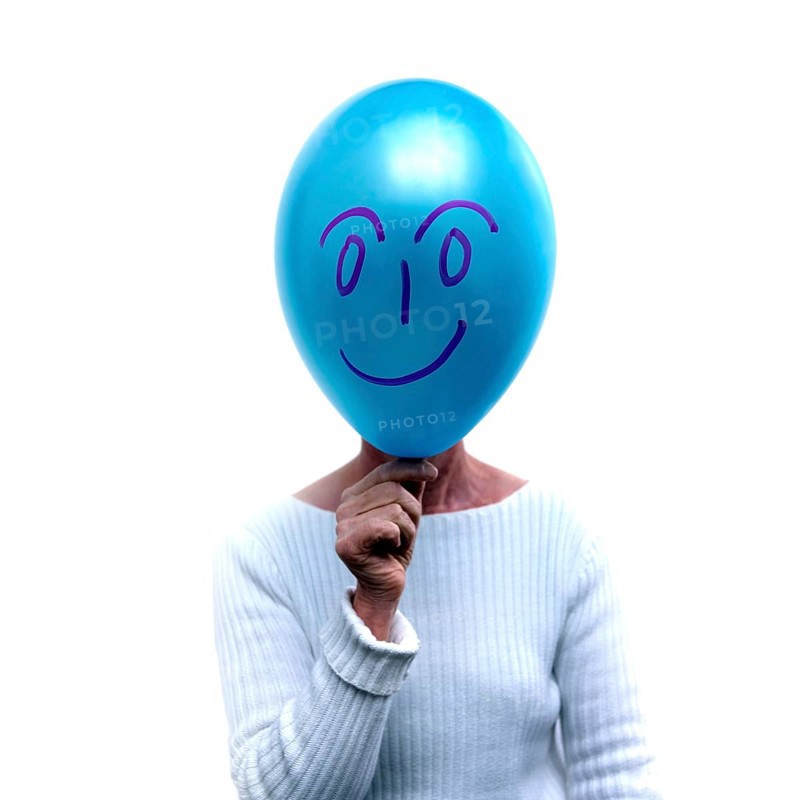 Woman with a blue balloon in front of her face