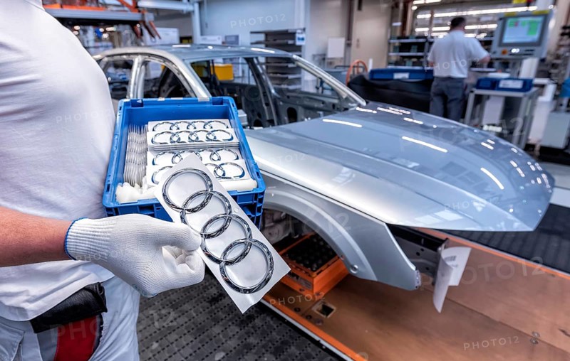 An Audi employee holds a box of Audi logos in the hands of the Audi A4 assembly line at the Audi AG plant in Ingolstadt