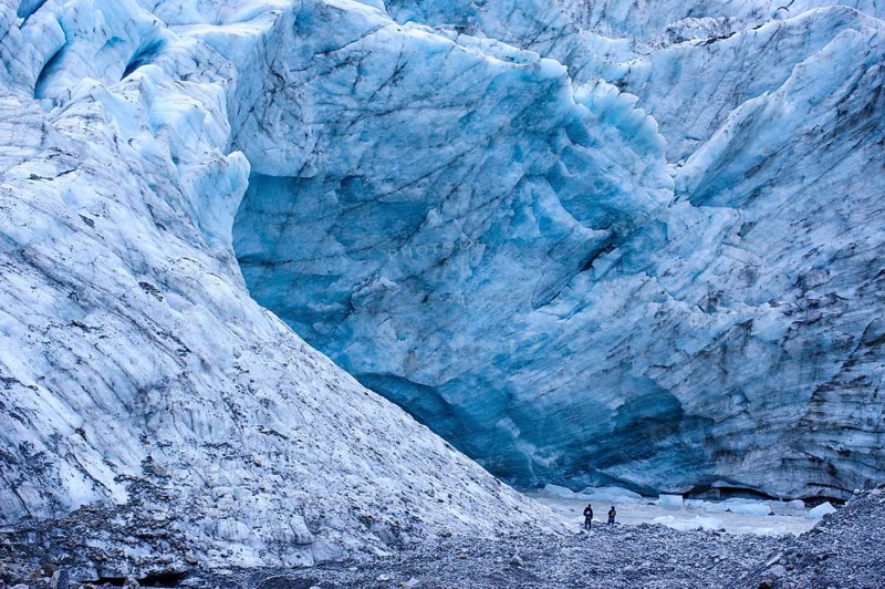 Tourist hiking to the giant glacial outflow of Fox Glacier
