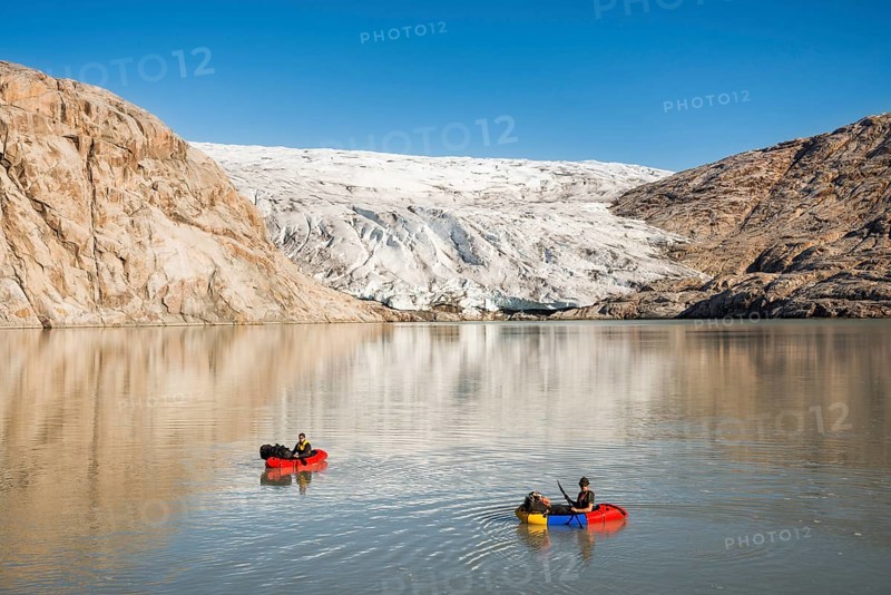 Two persons with pack rafts on fjord