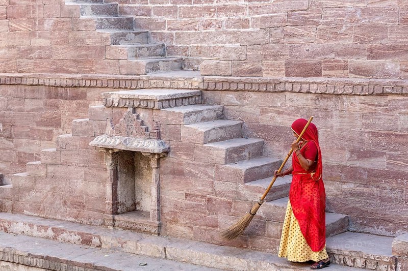 Woman in Sari cleaning the steps at Toorji Ka Jhalara