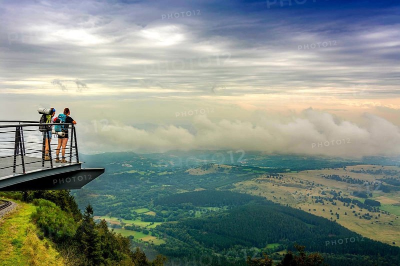 Walkers on a viewing platform facing the Limagne plain Regional Nature Park of the Volcanoes of Auvergne