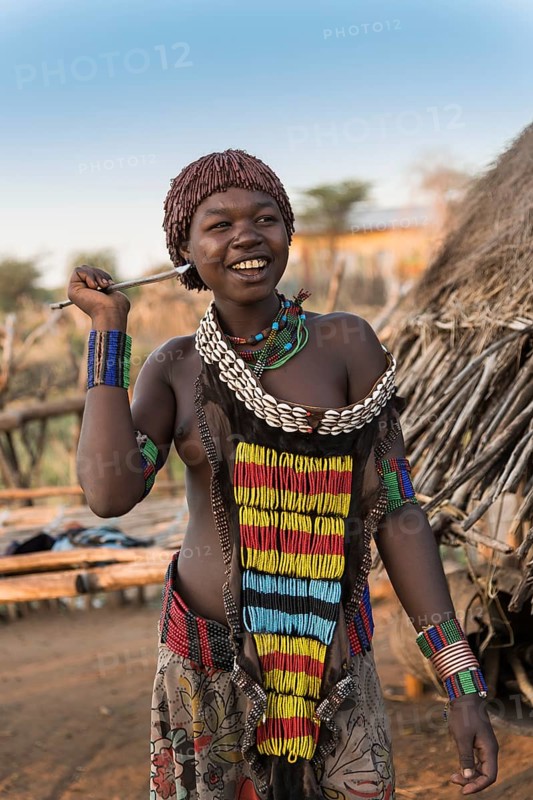 Young girl in traditional dress with necklace and spear