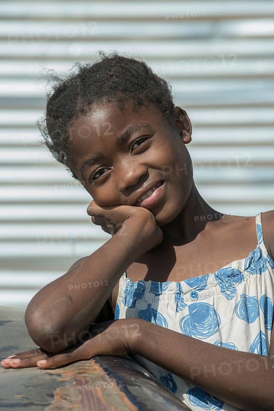 A girl is playing a car wreck in the slum district