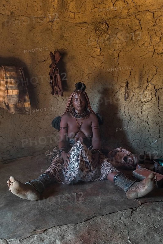Woman of the Ovahimba or Himba people cleaning and disinfecting clothes and body