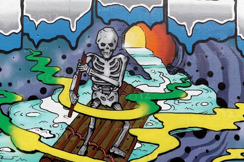 Human skeleton rows on a raft