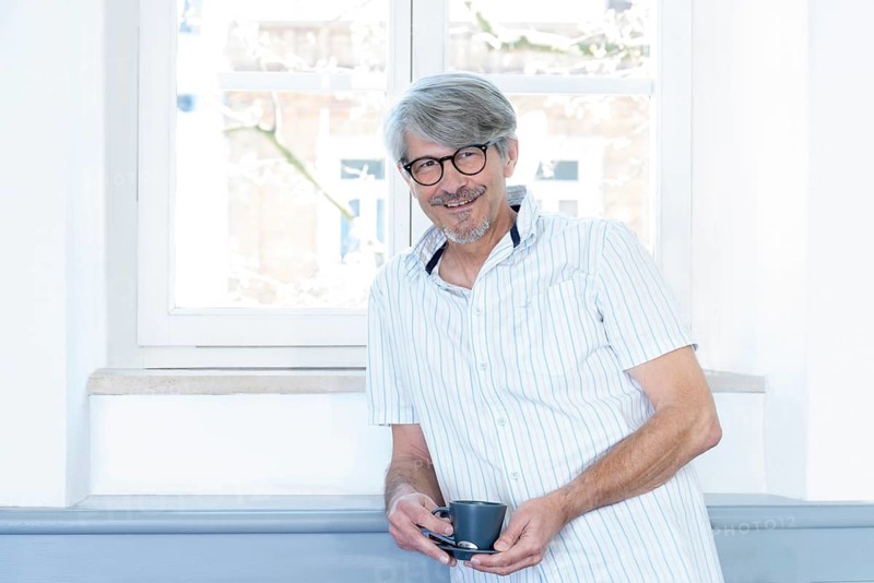 Man with coffee cup at his office window