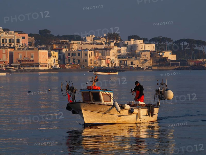 Fisherman early in the morning on his boat in the harbour