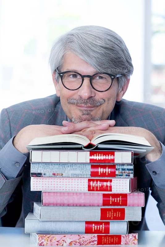 Man leaning on a book pile
