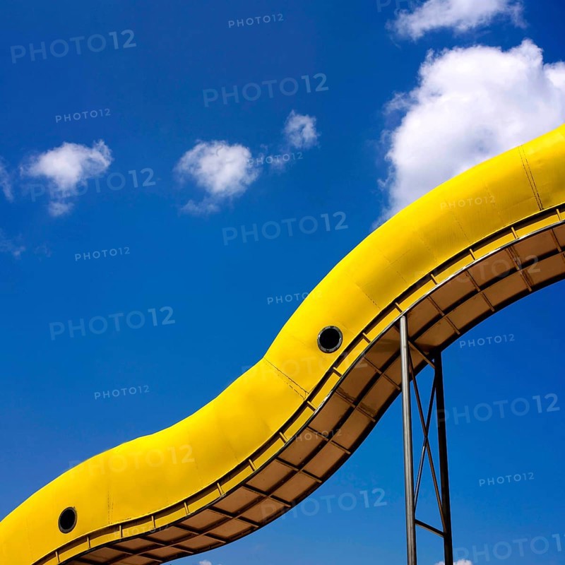 Yellow slide in front of blue sky