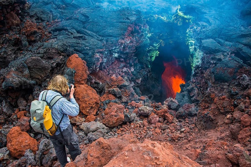 Tourist photographing an active magma stream below the Tolbachik volcano