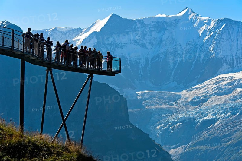 Tourists on the observation deck of the First Cliff Walk by Tissot in front of the Fiescherhorn north face and the Grindelwald glacier