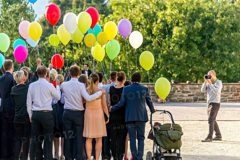 Photographer takes photos of a festive gathering with colourful balloons