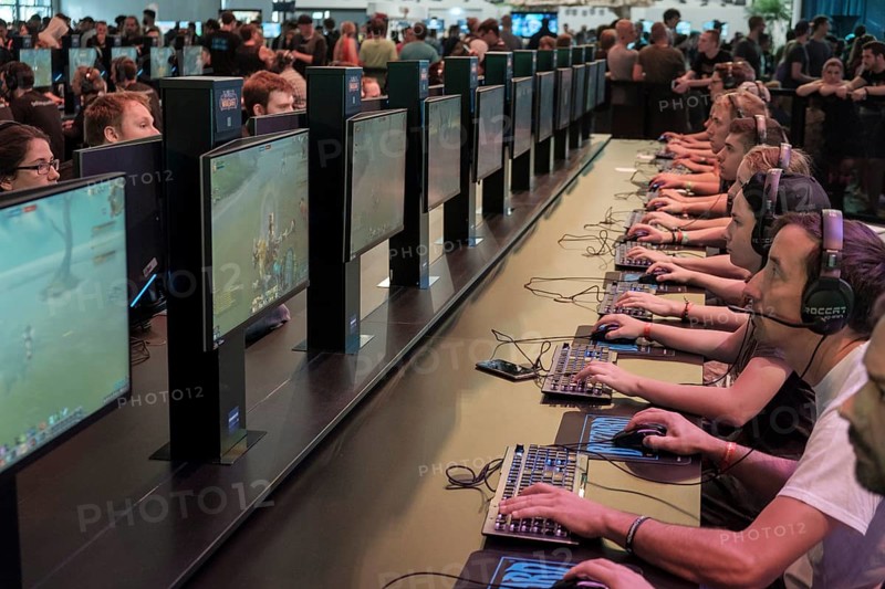 Visitors playing the computer game World of Warcraft in front of screens