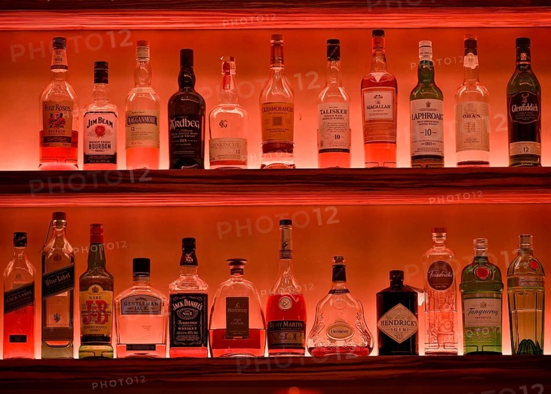 Various whisky bottles on the shelf of a bar