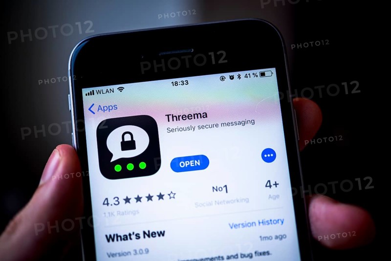 Hand holding iPhone with Threema