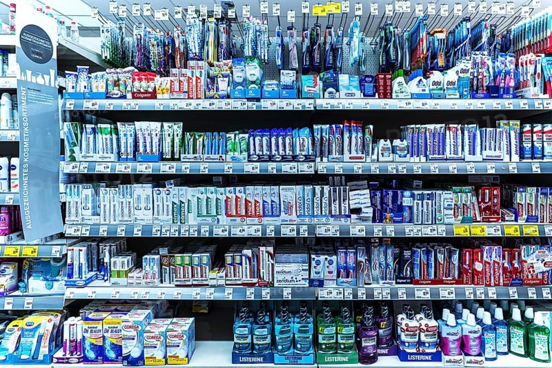 Toothpaste and toothbrushes in a supermarket shelf