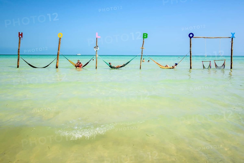 Tourists in hammocks on a beach