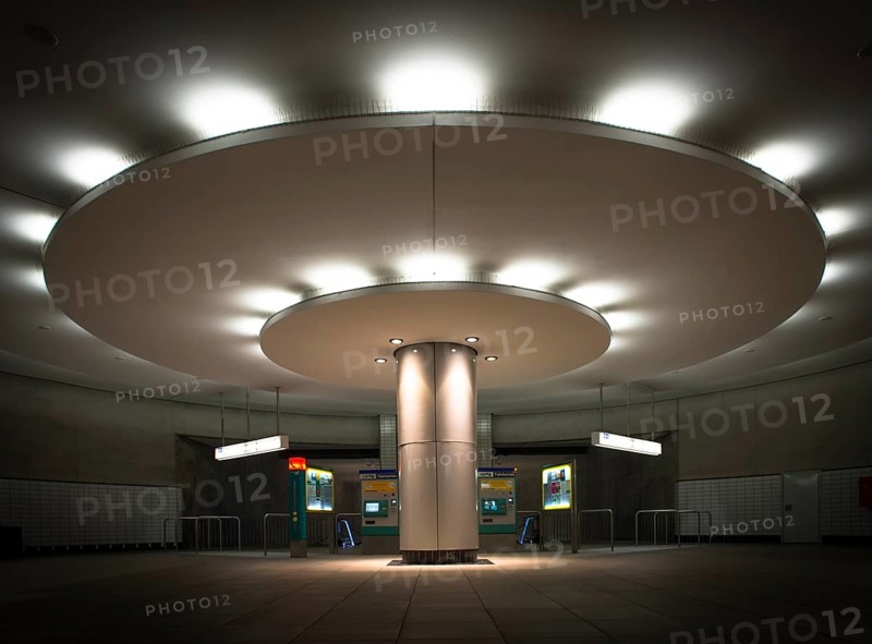 Illuminated column in entrance hall with ticket machine