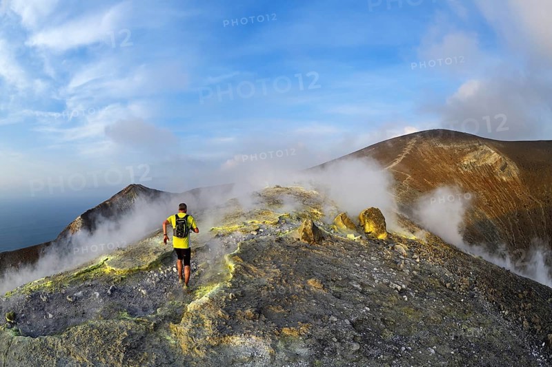 Trailrunner surrounded by sulfur fumaroles and chloride crusts on the crater rim