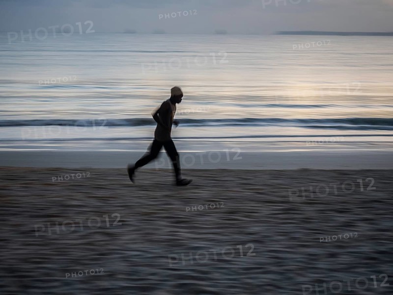 Local athlete doing morning exercise at dawn on the beach at Dar es Salaam