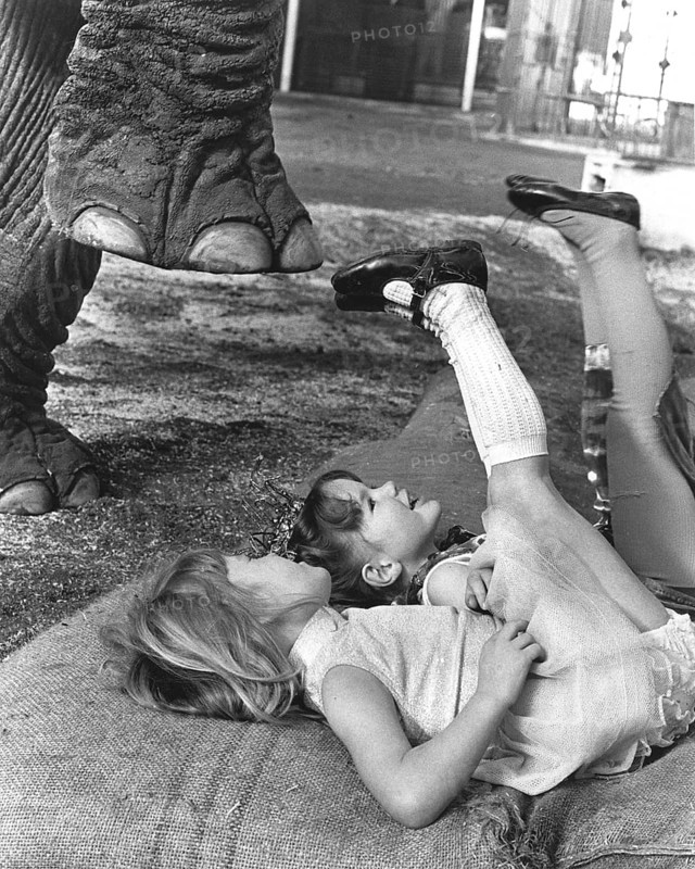 Two girls playing with an elephant