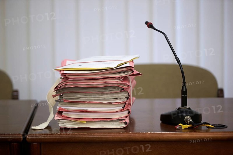 Trial files are on a judge's table in the courtroom