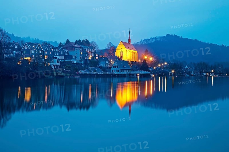 Beyenburg reservoir with the illuminated church of St. Mary Magdalene in the evening