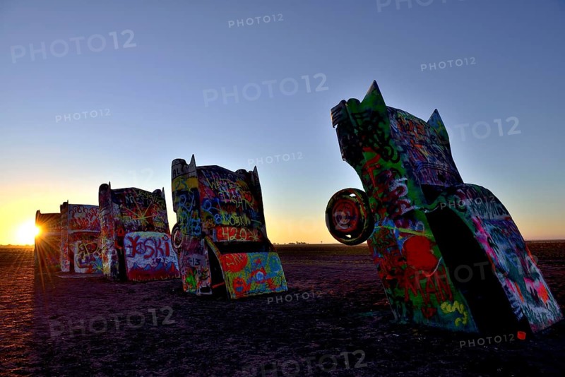 Sunset behind painted Cadillacs