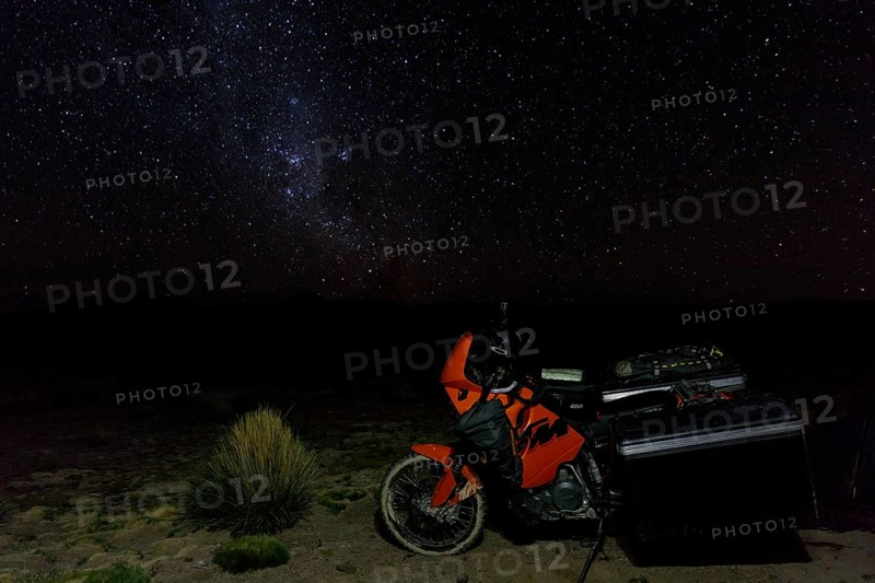 Heavily packed motorcycle on the plateau in front of the starry sky